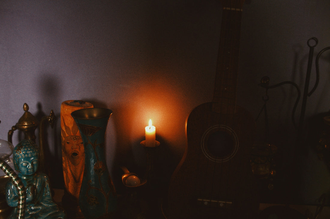 a room with a guitar, candle and other items