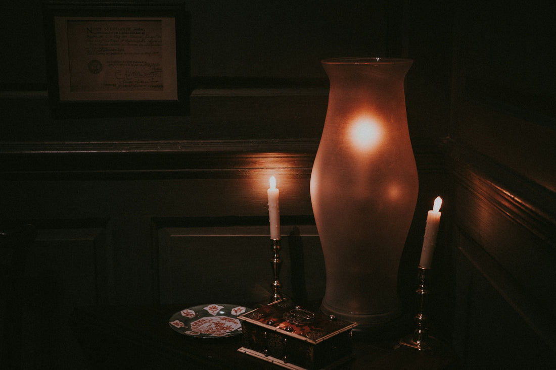Candles and decorative box on a dark surface.