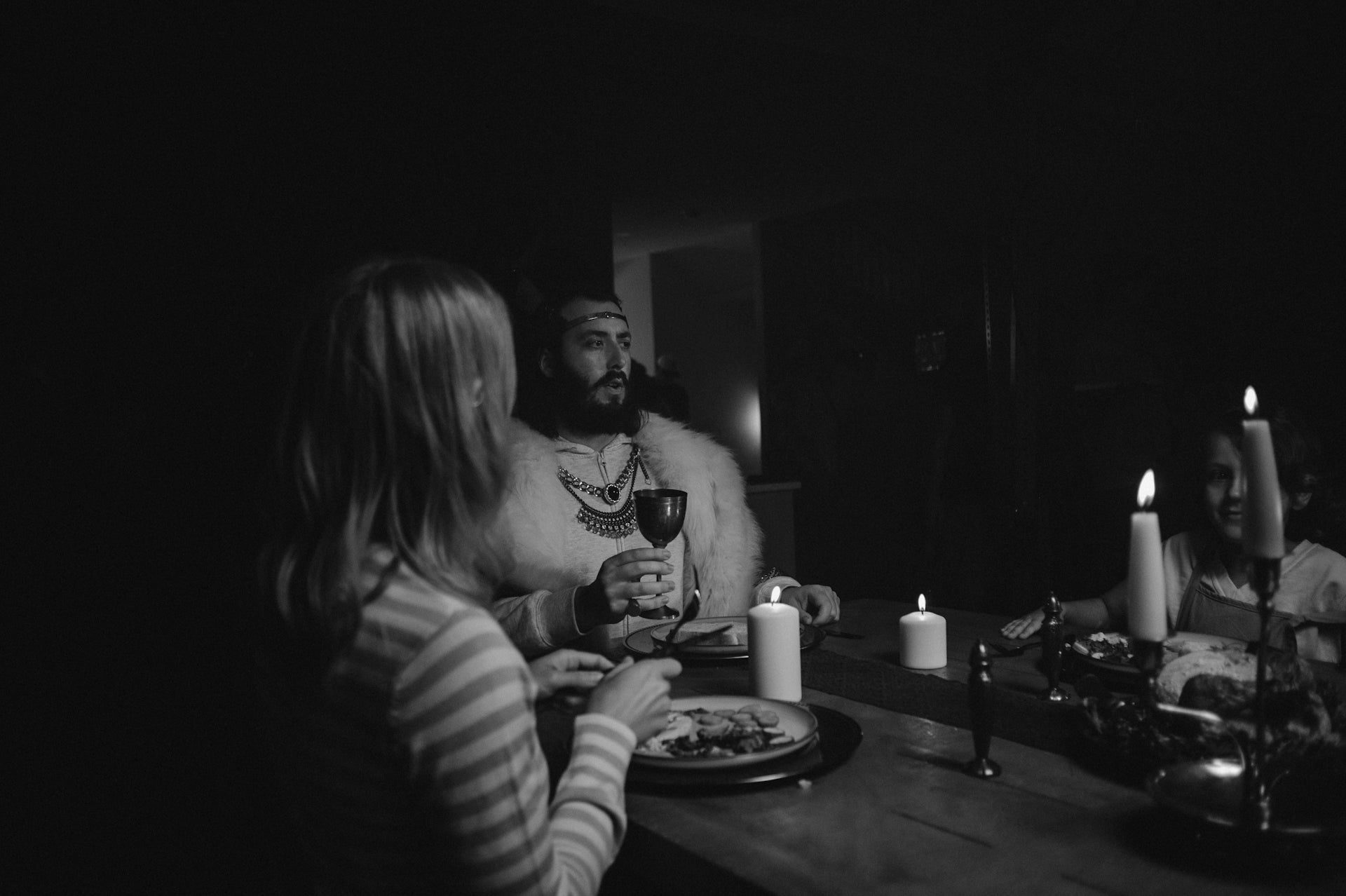 People dining by candlelight in dark room