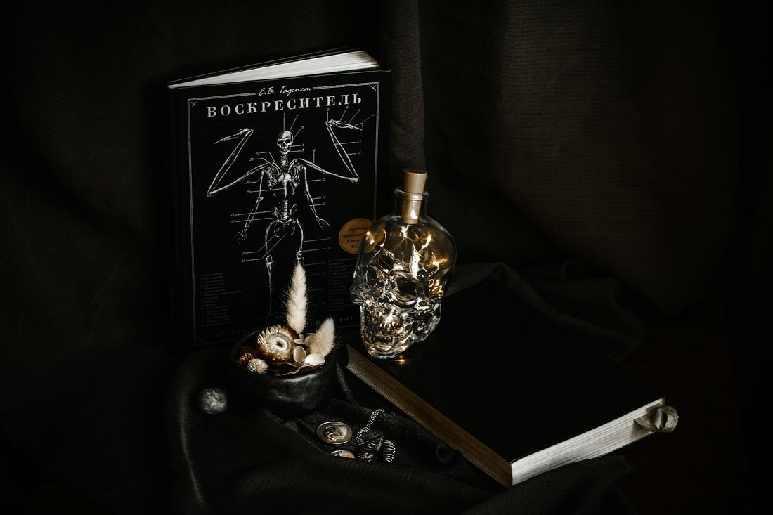 Dark still life with skull bottle and books